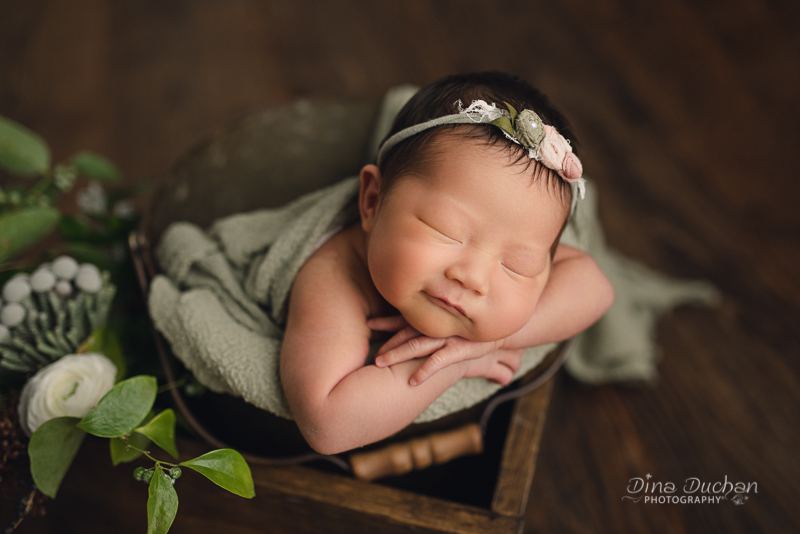 Brooklyn Newborn Photography baby smiling in crate with flowers